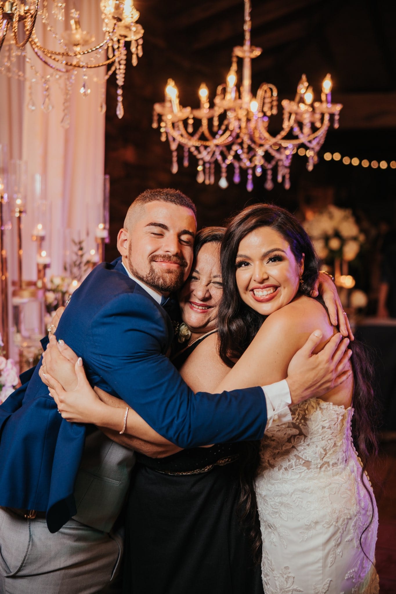 Novios abrazándose bajo chandelier en recepción coordinada por Nydia Acevedo CoordEvent